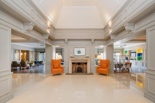 梅德斯通假日梅德斯通-七橡树酒店的大堂设有橙色椅子和壁炉
