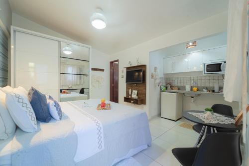 纳塔尔Pousada Recanto da Família的一间带白色床的卧室和一间厨房