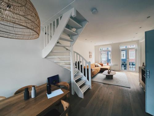 阿姆斯特丹Spacious Designer Duplex next to Central Park的带沙发的客厅内的螺旋楼梯