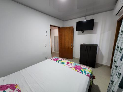 普罗维登西亚Posada Old Town Bay的卧室配有一张床,墙上配有电视。