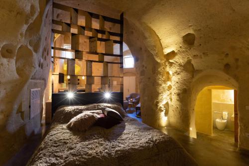 马泰拉Grotta Barisano的卧室配有一张石墙床
