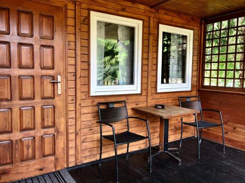 StęszewAB Domki całoroczne nad jeziorem的木制客房配有桌子和两把椅子