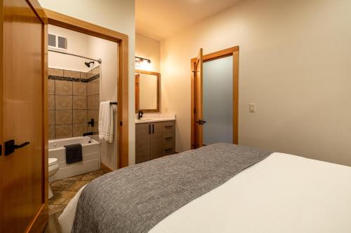 莱文沃思Alpen Dorf Pension的一间卧室配有一张床,浴室设有浴缸