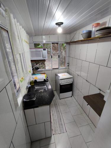 蜜岛Morada das Flores Chalé/Kitnet的一间带水槽和炉灶的小厨房