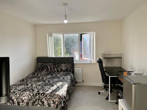 史云顿Large Double Room & Private EnSuite Bathroom, Badbury Park, Swindon, Near Great Western Hospital的一间卧室配有一张床、一张书桌和一个窗户。
