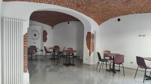 诺瓦拉Novara的配有桌椅的房间和砖墙