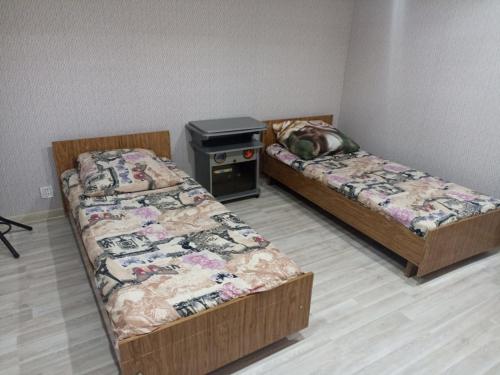 连科兰Частный дом Ленкорань的配有炉灶的客房内设有两张床。