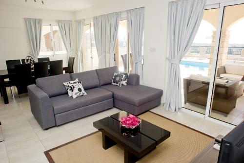 帕福斯圣乔治俱乐部公寓式酒店的客厅配有沙发和桌子