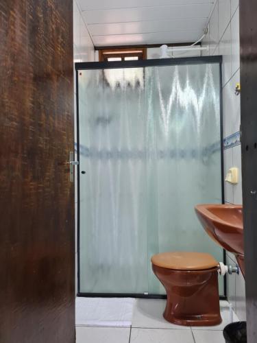 邦比尼亚斯Sunshine Residencial的一间带卫生间和玻璃淋浴间的浴室