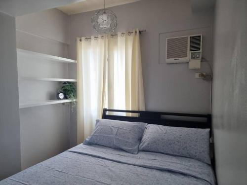 马尼拉One Bedroom Condo in Makati的一间卧室设有一张床和一个窗口