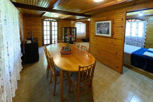 新文达移民镇Chalé Dei Fiori, 3QTS, Ambiente Ideal para a família的一间带桌子的用餐室和一间卧室