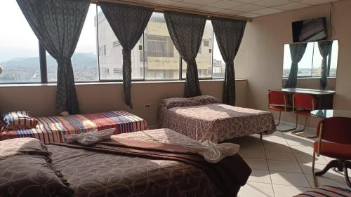 瓜亚基尔Hotel Sol de Oro的酒店客房设有两张床和窗户。