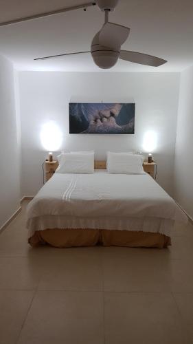Kefar WeradimRosewood的白色卧室配有一张带两盏灯的大床