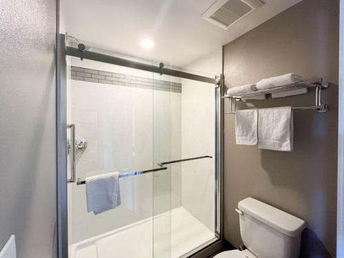 洛杉矶Motel 6 Los Angeles, CA - Downtown的带淋浴的浴室以及带玻璃门的卫生间。