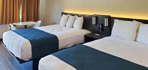 洛杉矶Motel 6 Los Angeles, CA - Downtown的酒店客房设有两张床和一张桌子。