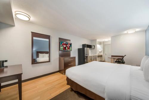圣安东尼奥HomeTowne Studios by Red Roof San Antonio - SeaWorld Northwest的酒店客房设有一张大床和一张书桌。