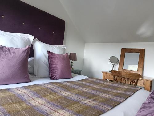 Rowlands CastleKeepers Retreat的一间卧室配有一张带紫色和白色枕头的床