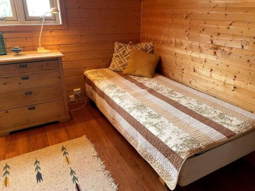 纳姆索斯Stille og landlig, men sentrumsnær leilighet的一间卧室设有一张床和木墙