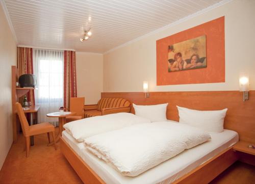 埃伦茨-波尔特斯多夫阿尔特温申克宾馆的卧室配有白色的床和桌子