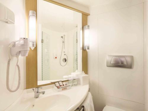 巴厘巴板巴厘巴板宜必思酒店的白色的浴室设有水槽和淋浴。