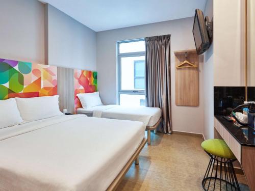 新加坡ibis budget Singapore Clarke Quay的一间酒店客房,设有两张床和电视