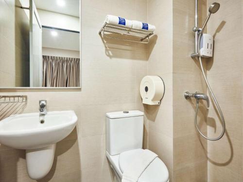 新加坡ibis budget Singapore Clarke Quay的浴室配有卫生间、盥洗盆和淋浴。