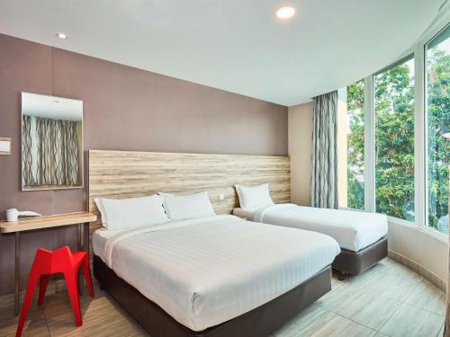 新加坡ibis budget Singapore Crystal的酒店客房带两张床和一张红色凳子