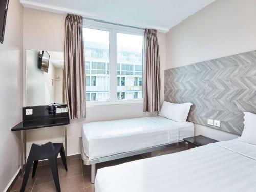 新加坡ibis budget Singapore Ruby的酒店客房设有两张床和窗户。