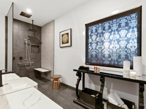 Meeniyan美洋坎帕尼亚旅馆的墙上设有大电视的浴室