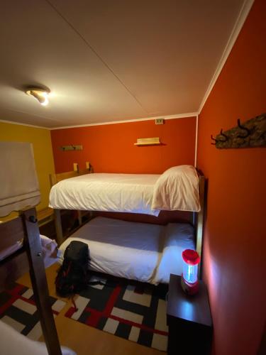 百内三塔孔卡什根旅舍的一间卧室设有两张床和红色的墙壁