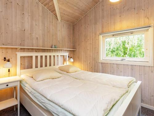 奥特鲁普Holiday home Otterup XVIII的卧室配有一张木墙内的大床