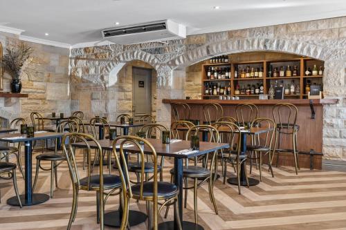 袋鼠谷Wildes Hotel Kangaroo Valley的一间带桌椅的餐厅和一间酒吧