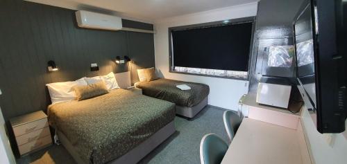 扬Goldrush Motel Young CBD的小房间设有两张床和窗户