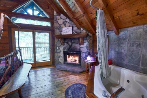 赛维尔维尔Wild Columbine - Gatlinburg Area Hottub Romantic Cabin的带浴缸的浴室和壁炉。