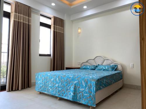 芽庄Coastal House Nha Trang的一间卧室配有一张带蓝色床单和窗户的床。