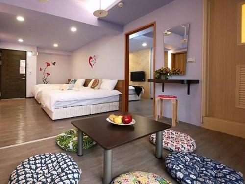 高雄美丽岛福憩旅店的一间卧室配有一张床和一张桌子及一碗水果