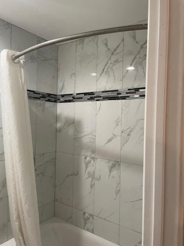 波莫纳Travelodge by Wyndham Fairplex Pomona的浴室设有白色大理石瓷砖和淋浴。
