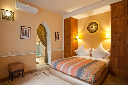 马拉喀什茵尚特旅馆的卧室配有床、椅子和窗户。