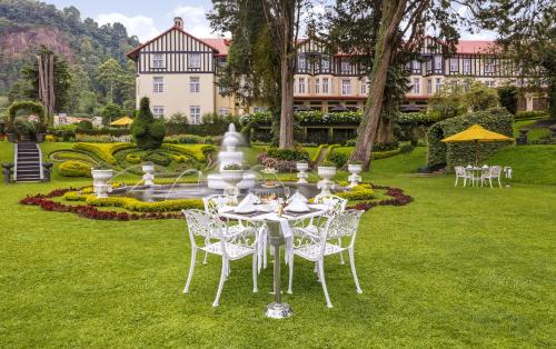 努沃勒埃利耶The Grand Hotel - Heritage Grand的一张桌子和椅子位于一座大建筑前