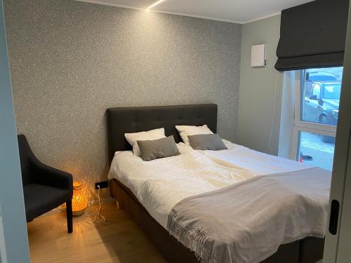 哈普萨卢Vanalinna apartment的一间卧室配有一张带椅子的床和一扇窗户