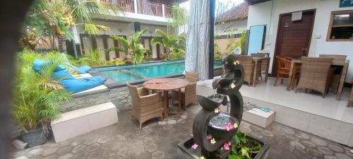 蓝梦岛斯瓦亚民宿2号的一个带桌椅的庭院和一个游泳池