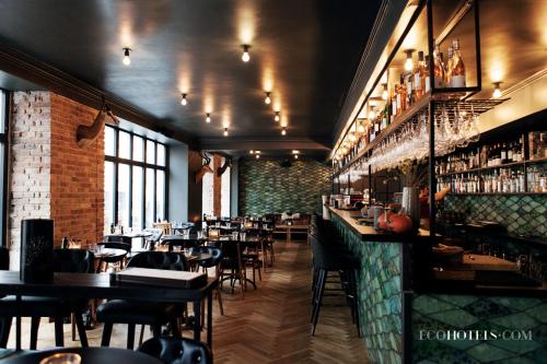 哥本哈根阿科斯尔古尔德斯梅登酒店的餐厅设有酒吧,配有桌椅