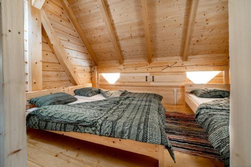 Stari Trg pri LožuDormitory and wooden house Beli gaber的小木屋卧室设有两张木墙床