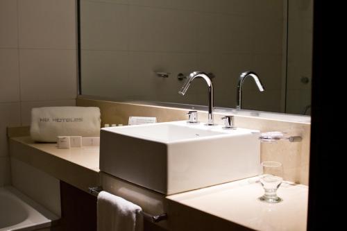 内乌肯Hotel Comahue Business的浴室设有白色水槽和镜子