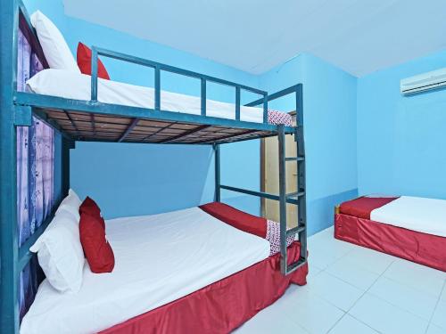 哥打巴鲁OYO 90454 Haza Harmoni Guesthouse的蓝色天花板的客房设有两张双层床。