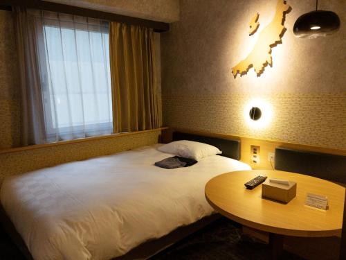 新泻HOTEL GLOBAL VIEW Niigata的酒店客房设有一张大床和一张桌子。