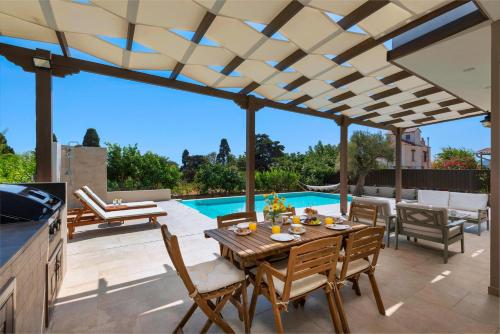 阿斯格罗Cypress View Boutique Villa的一个带桌椅的庭院和一个游泳池