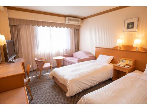 伊势市Hotel Castle Inn Ise Meotoiwa的酒店客房设有两张床和电视。
