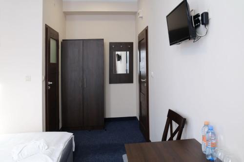 华沙Baza Hotelowa Bobrowiecka 9的客房设有1张床、1张桌子和1台电视。