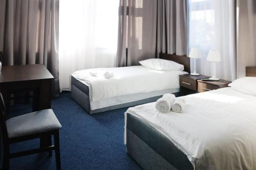 华沙Baza Hotelowa Bobrowiecka 9的酒店客房配有两张床和一张书桌